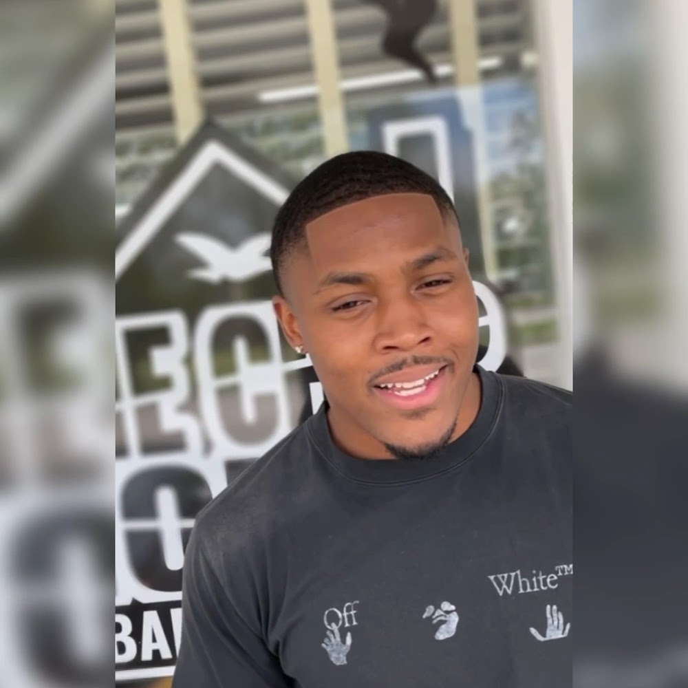 Client with a clean fade in front of The Chop House logo